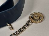 a blue belt with a gold buckle and a chain attached to it