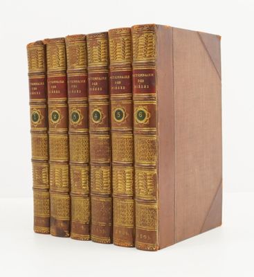 a set of five books sitting on top of each other on a white surface
