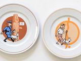 two plates with pictures of a man and a dog on them