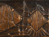 a metal plaque with a fish design on it