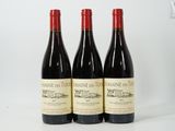 trois bouteilles de vin rouge posées côte à côte sur une table