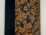 un livre orné de crânes, posé sur une table