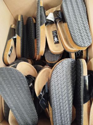 plusieurs paires de chaussures dans une boîte posée sur le sol