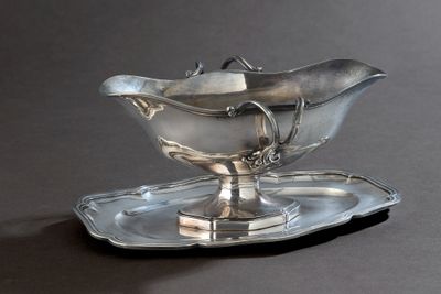 une assiette en argent sur laquelle est posée une soucoupe en argent