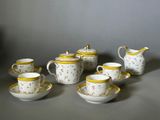 une image représentant un ensemble de tasses à café et de soucoupes posées sur une table