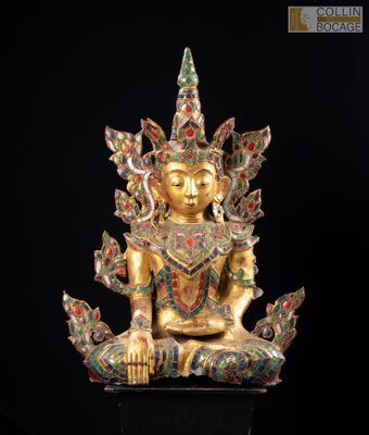 une statue en or représentant une personne assise sur une surface noire
