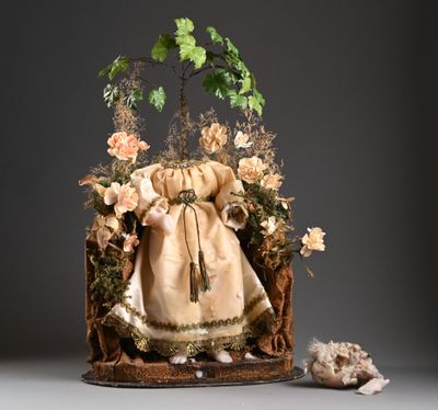 une poupée assise dans une boîte décorée de fleurs