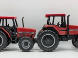 two red toy tractors that are sitting side by side