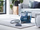 un aspirateur posé par terre dans le salon