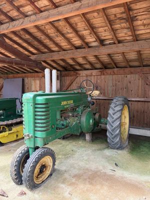 un tracteur vert et un tracteur jaune à l'intérieur d'une grange