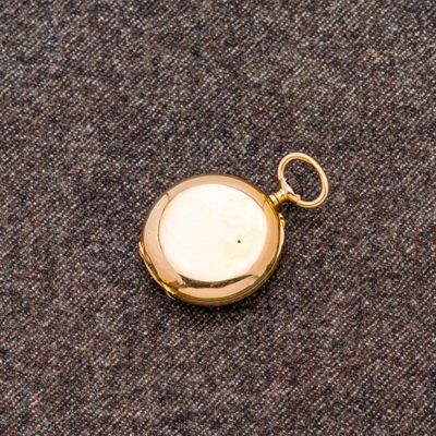 une vieille montre de poche en or, avec une chaîne suspendue sur le côté