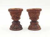 deux vases en bois posés l'un à côté de l'autre sur une surface blanche