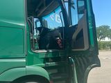 a large green truck with its door open in a parking lot