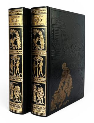 un vieux livre à la couverture noire ornée d'illustrations dorées