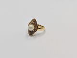 an image of a gold ring with a pearl in the center