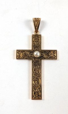 une image représentant une croix en or avec une perle au centre