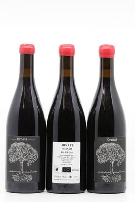 trois bouteilles de vin posées les unes à côté des autres sur une surface blanche