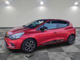 Une voiture rouge est garée sur un sol carrelé à damier.