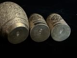 trois vases en argent posés les uns à côté des autres sur une surface noire