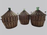 trois paniers marron sur lesquels sont posées des bouteilles vertes