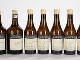 six bouteilles de vin sont alignées sur une surface blanche