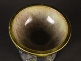 a brown and black vase sitting on a black surface