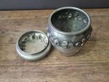 a small metal container sitting on a wooden table