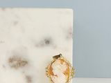 un gros plan sur une dalle de marbre blanc sur laquelle repose une broche en or