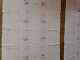 two pieces of fabric hanging on the wall next to each other