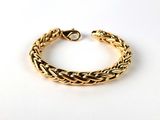 a close up of a gold bracelet on a white surface