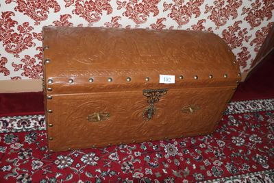 a brown trunk sitting on a red carpet