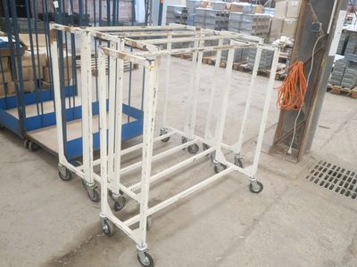 un chariot en métal blanc muni de roues, dans un entrepôt