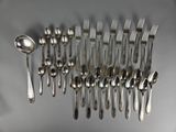 many forks and spoons laid out on the table