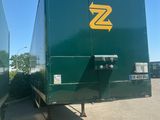 a green semi trailer parked in a parking lot