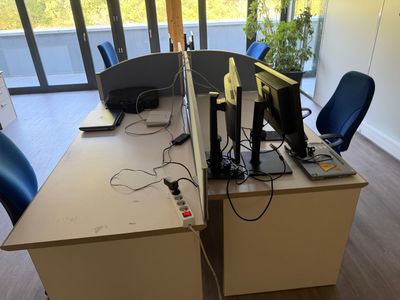 un bureau sur lequel se trouvent deux ordinateurs et un écran