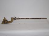 an old gun with a wooden handle on a white surface