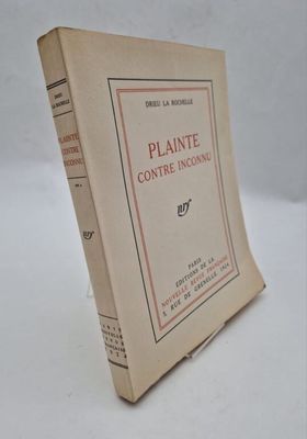 an old book sitting on top of a white table next to a white wall