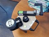 un appareil photo posé sur une table, avec une pile de papiers en arrière-plan