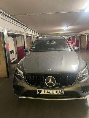 une voiture garée dans un parking couvert, avec une plaque d'immatriculation à l'avant