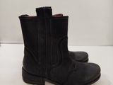 pair of black leather boots sitting on a white surface
