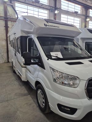 deux camping-cars blancs garés dans un grand entrepôt