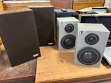 three speakers sitting on top of a table next to a laptop