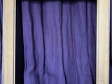 a picture of a picture frame with a purple curtain in the background