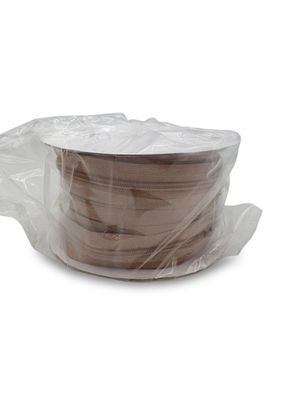 une bobine de plastique emballée dans du plastique posée sur une surface blanche