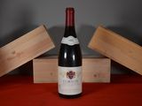 une bouteille de vin posée sur une table, à côté de deux caisses en bois