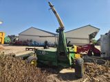 un tracteur qui est à l'arrêt dans la terre, près d'un bâtiment