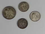 four different types of coins are shown on a white surface