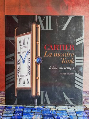 une image représentant un livre sur lequel figure une horloge, posé sur une table