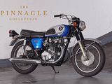 a blue motorcycle parked in front of a white wall