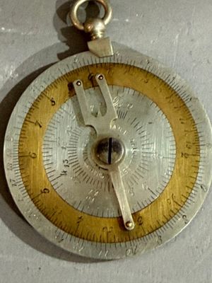 une horloge argentée et dorée posée sur un fond blanc